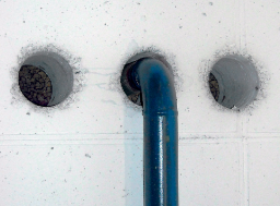 Openings in concrete wall in contact with the ground with an air-permeable pipe penetration.