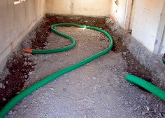 Photo of a radon drain on a gravel bed before the new floor construction.