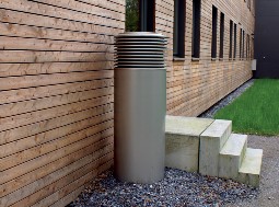 Photo of a fresh air intake with a height of 1.5 meters next to a house wall.